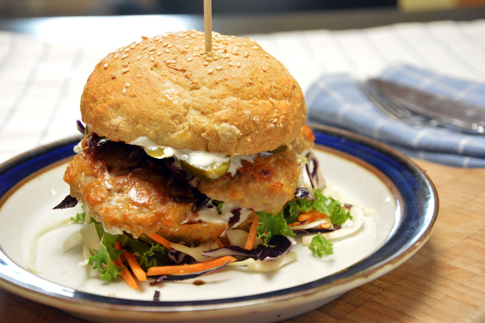 Köttbullemacka i hamburgerbröd med kålsallad, rödkål och skivad saltgurka, hopsatt med en grillpinne av trä