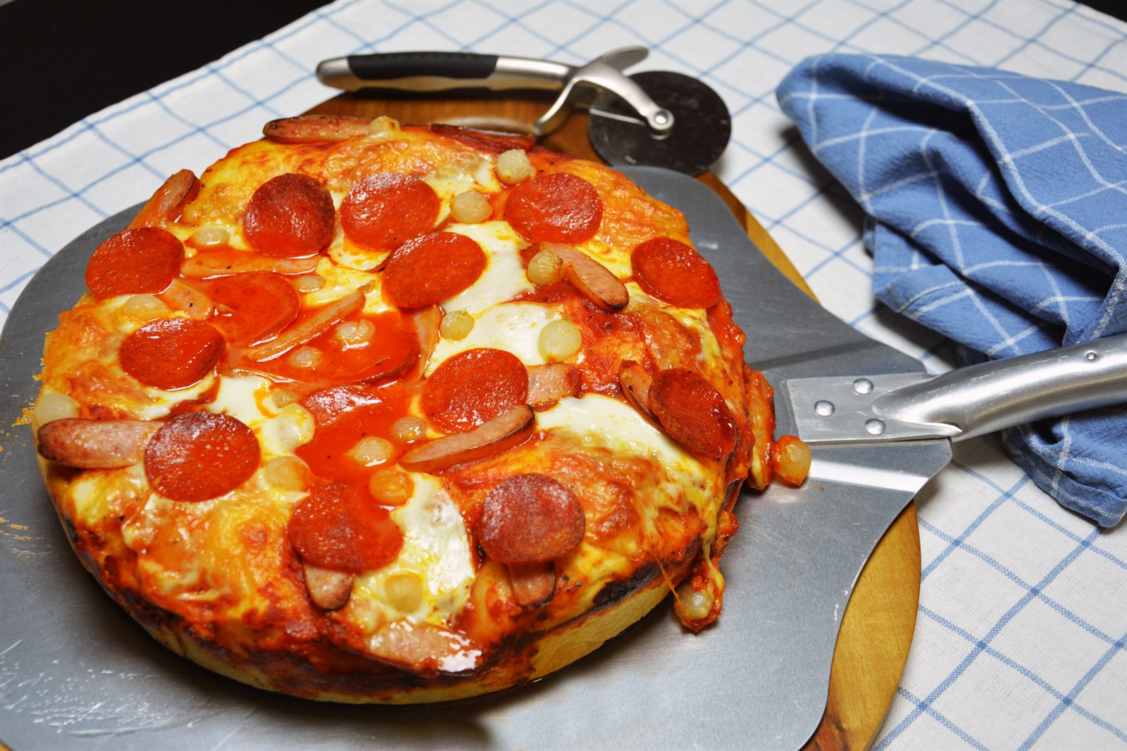 Pan pizza med tjock botten, smält mozzarella, pepperoni och syltad pärllök